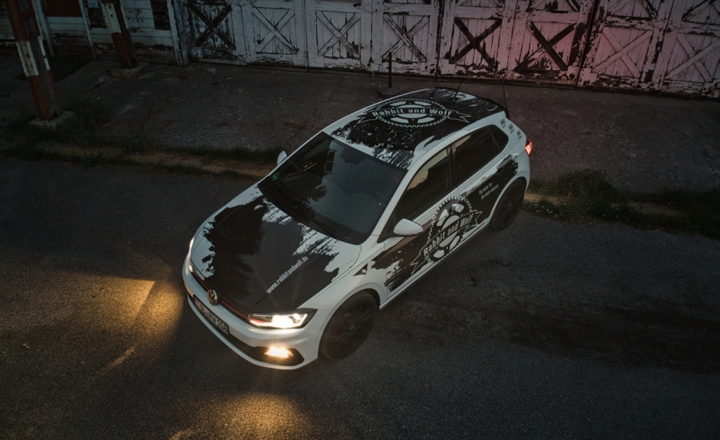 Weißer VW Polo mit schwarz-weißer Rabbit and Wolf Fahrzeugfolierung, großem Logo und dynamischen Farbflächen.